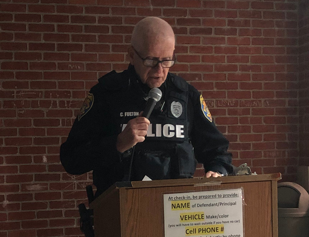 Patrol Officer Curt Fulton welcomes guests and community members to the ceremony at the police station.